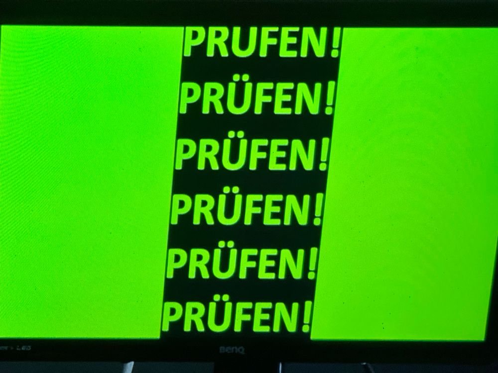 Grüner Bildschirm mit mehrfach dem Wort Prüfen, Ausrufezeichen