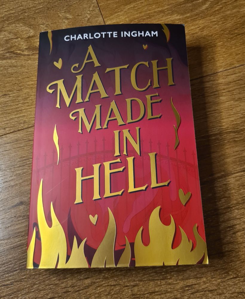 VERY PINK AND SHINY BOOK WITH GOLD FOILING 
A Match Made in Hell by Charlotte Ingham
With pink background and gold flames