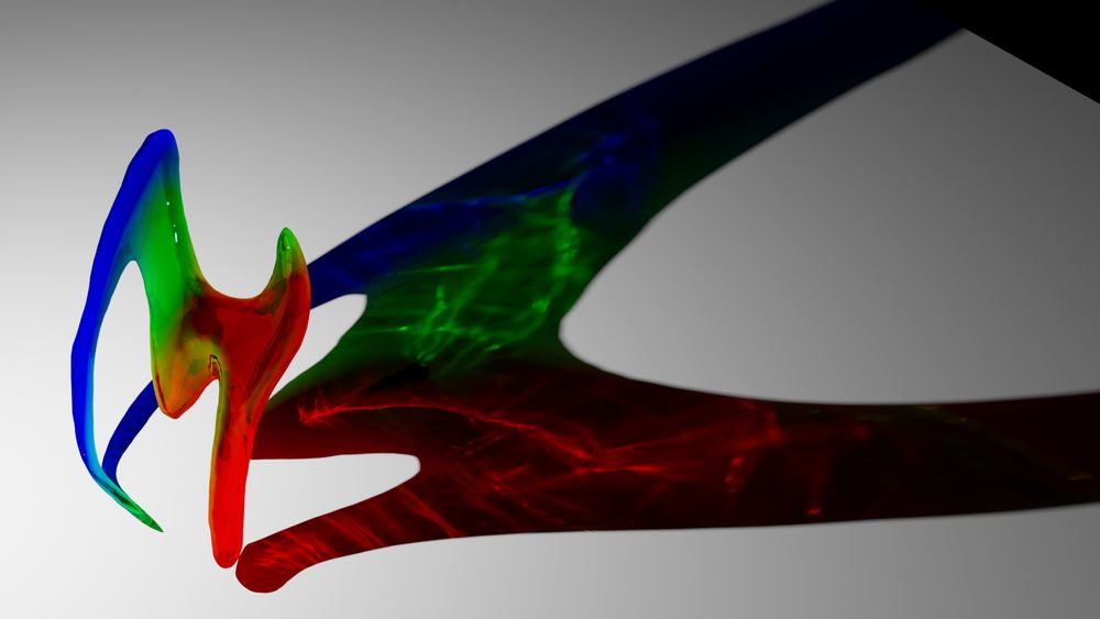 A 3D render of an abstract piece of glass, colored blue, green, and red. Swirling patterns are on the ground from a light refracting through the glass.
