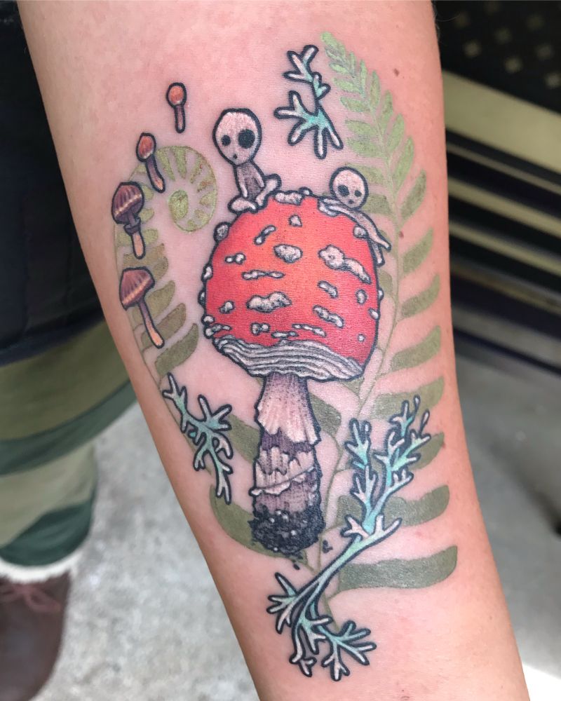 A tattoo of a red mushroom floating with lichen and a couple of Kodama climbing on the cap. There is a faint fern shadow behind which gives the whole piece a floating magical vibe