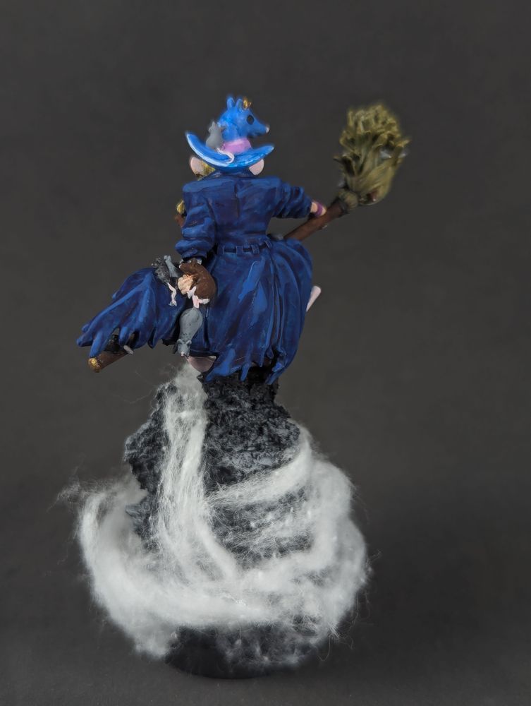 A rat wizard in blue, covered in cute rats, riding a broom atop a mountain. From behind.