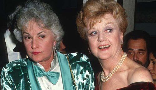 Bea Arthur and Angela Lansbury, the original Vera Charles and Mame Dennis from the musical Mame. Bea is wearing a teal green silk tuxedo, and Angela is wearing an off-the-shoulder red velvet gown and pearls.