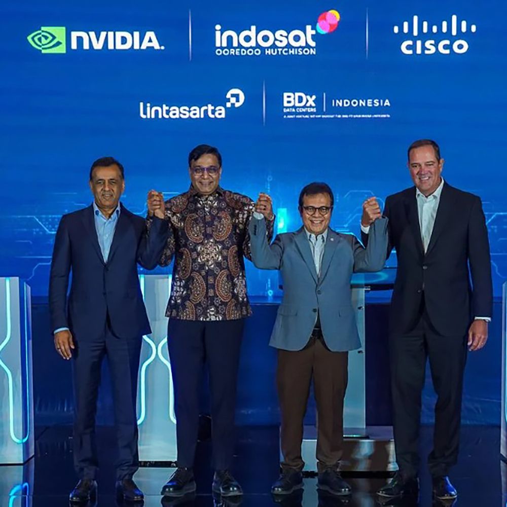 A picture of three men with Chuck on the stage at the AI center of excellence