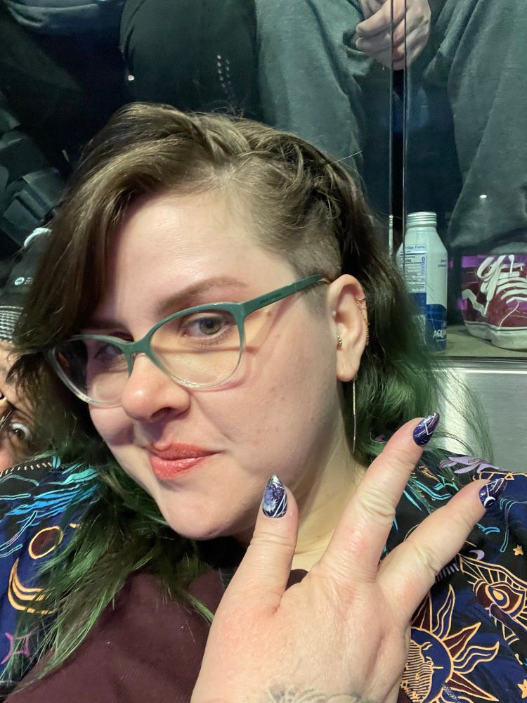 Myself showing off my Essek nails at the live show. (With a sus eye in the background)