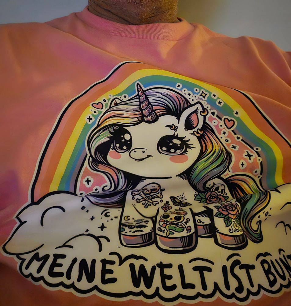 Ich mit einem rosa T-Shirt von Mandelkokainschnaps mit f einen Einhorn vorn drauf und in einer Weile der Schriftzug "Meine Welt ist bunt" hinten steht dann noch "Weil mein Schatz die Vielfalt ist" 