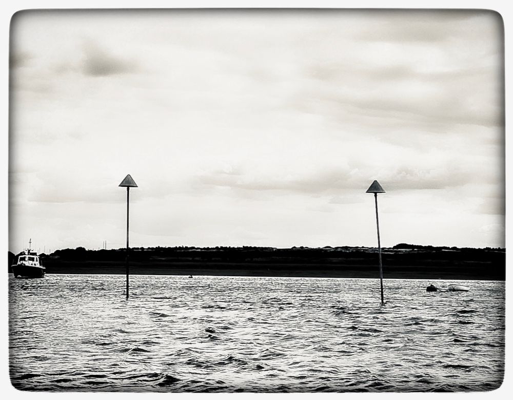 Poles w triangles and a boat and the sea 