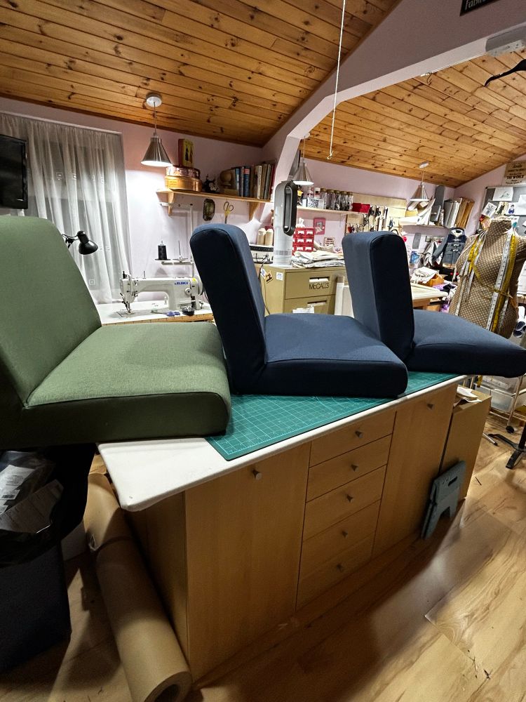 Picture shows three newly upholstered chairs (without the wooden frames). One green and two blue sitting on my cutting out table.