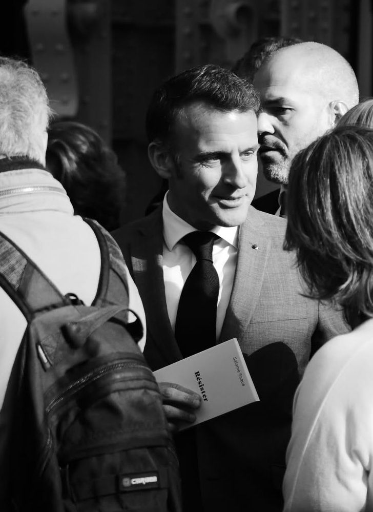 Emmanuel Macron qui tient le livre résister entre ses mains 