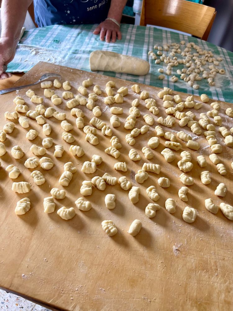 A wooden table full of raw potato gnocchi
