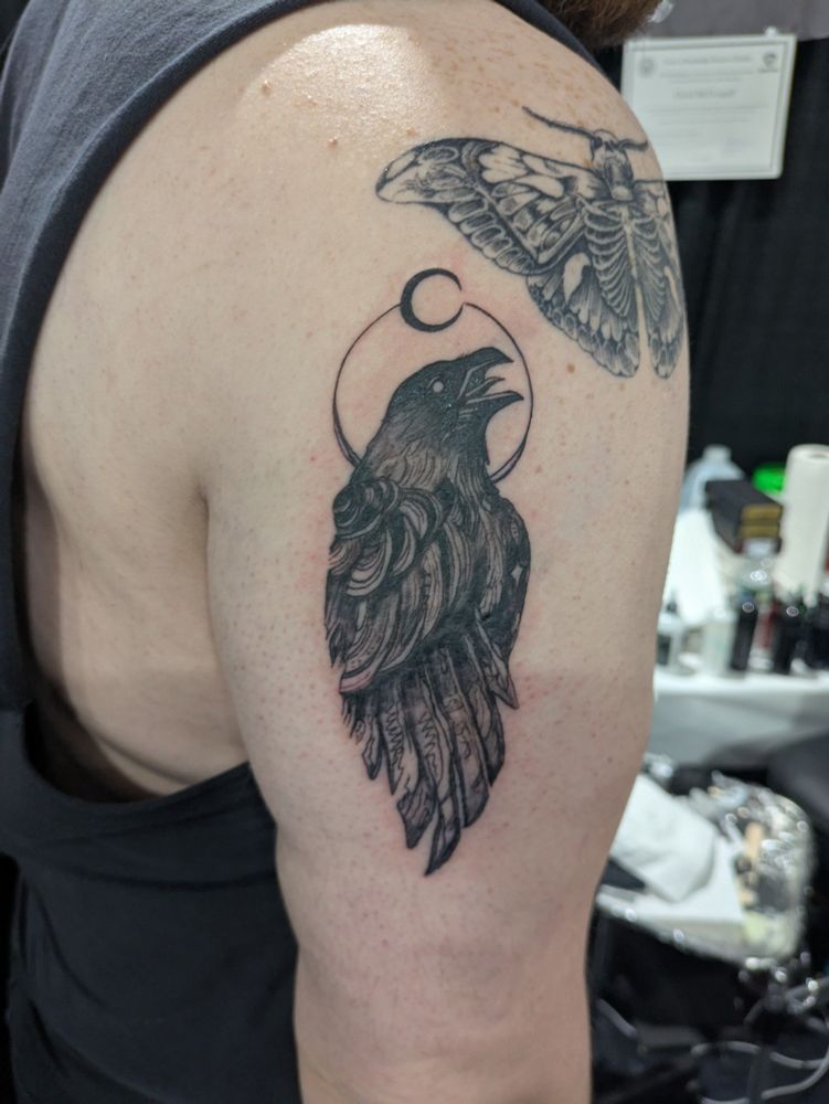 A tattoo of a crow beneath Crescent moon
