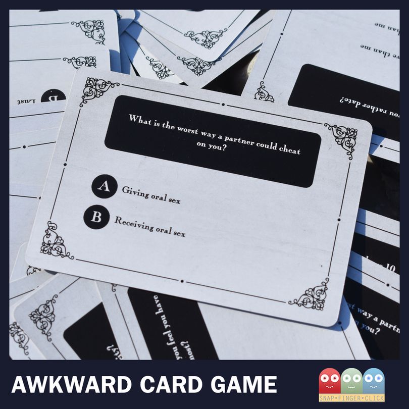 A close-up of a card from the Awkward Card Game asking: "What is the worst way a partner could cheat on you?" with options A) Giving oral sex and B) Receiving oral sex. Other cards are scattered in the background.