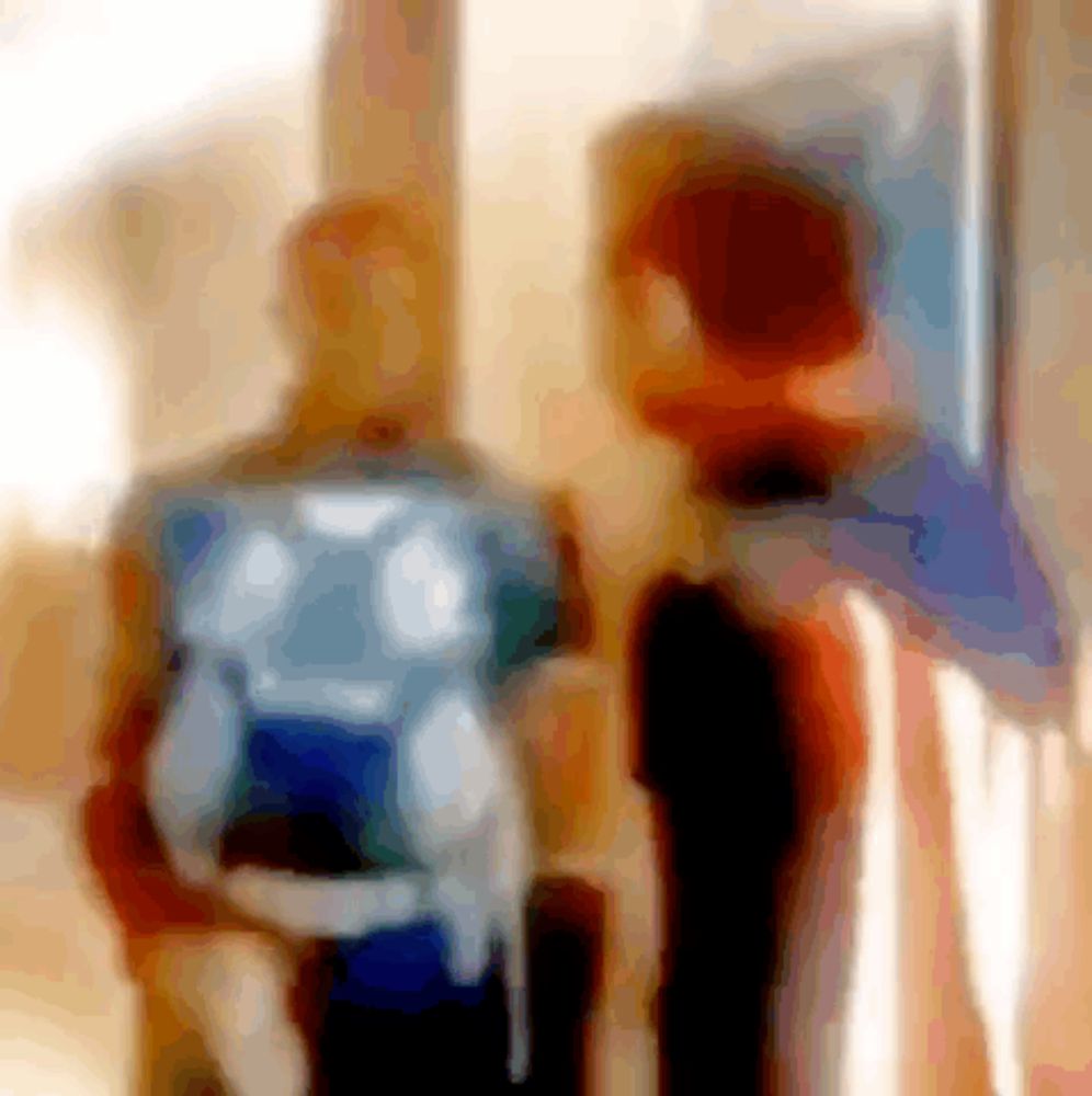 a blurry picture of two people with backpacks talking