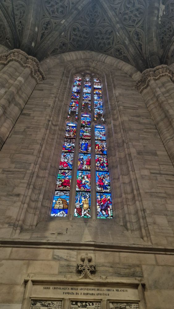 Ein hohes kirchenglasfenster in rot und blautönen