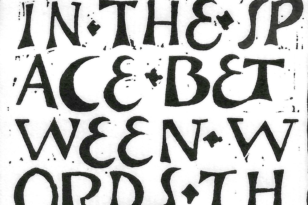 Detail from a linocut of black lettering on a white ground.  The letters spread across four short lines, three of which are taken up by the phrase ‘between words’.