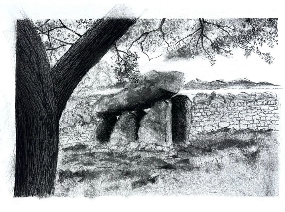 The bough of an oak tree frames a portal dolmen on which light falls, casting part of it in heavy shade.  A filigree of leaves reach down to the head stone of the dolmen.
