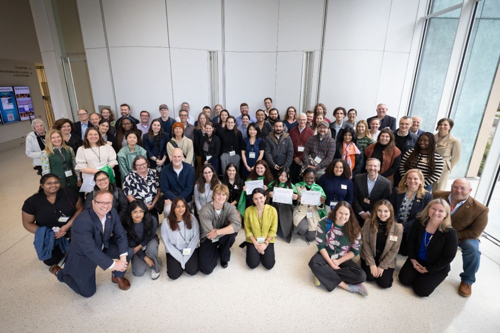 A large group of smiling people in a corporate space.
