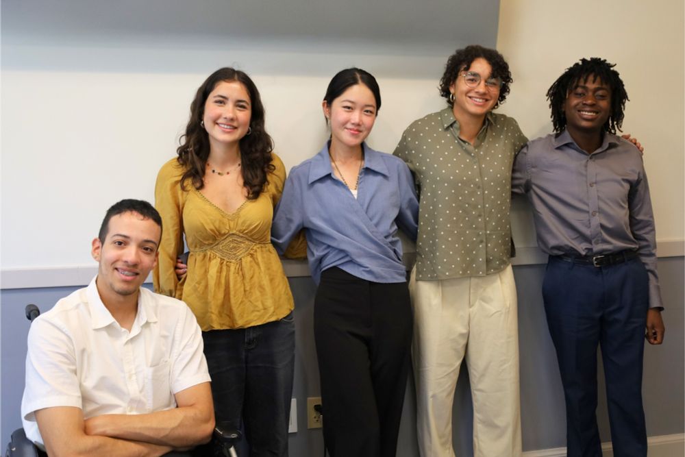 A group of five smiling students. 