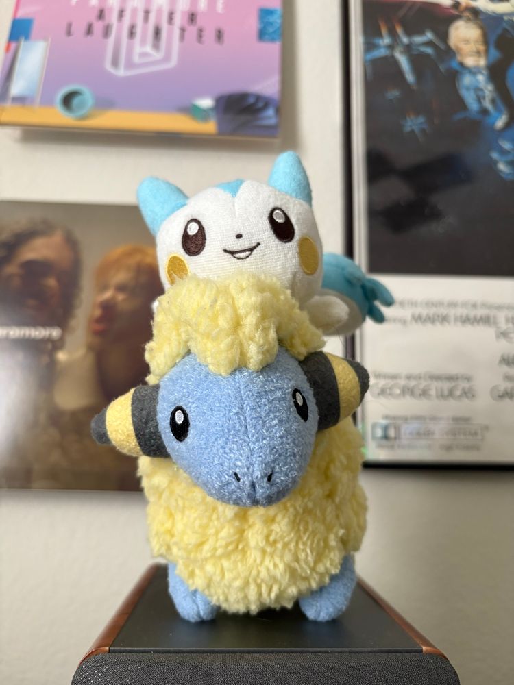 A pachirisu plush sitting on a mareep plush