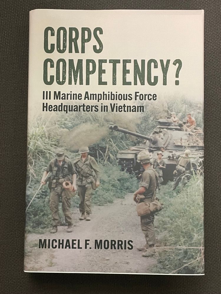 The cover of the book “Corps Competency? III Marine Amphibious Force in Vietnam” by Michael F Morris.

The cover is a colour photograph of USMC infantry and combat engineers sweeping a narrow jungle track in Vietnam for mines with a USMC M48 tank behind, while advancing to Khe Sanh in 1968.