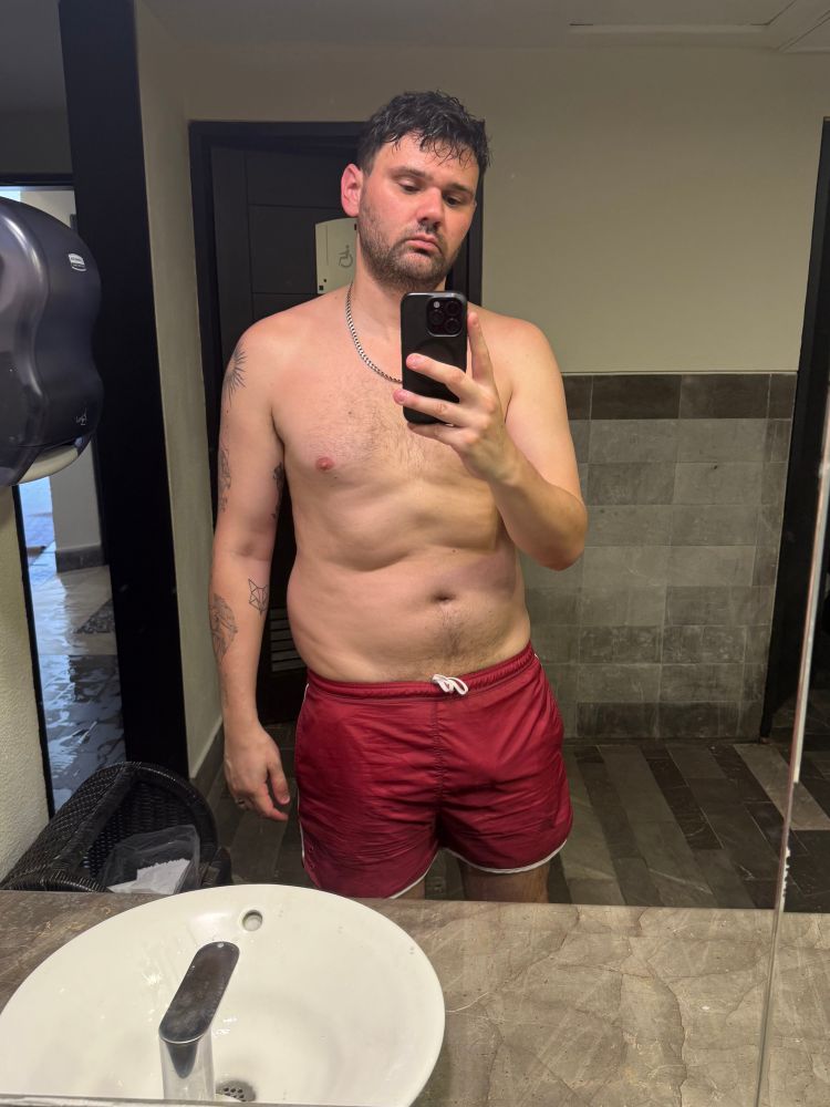 Mirror selfie of me in dark pink swim shorts