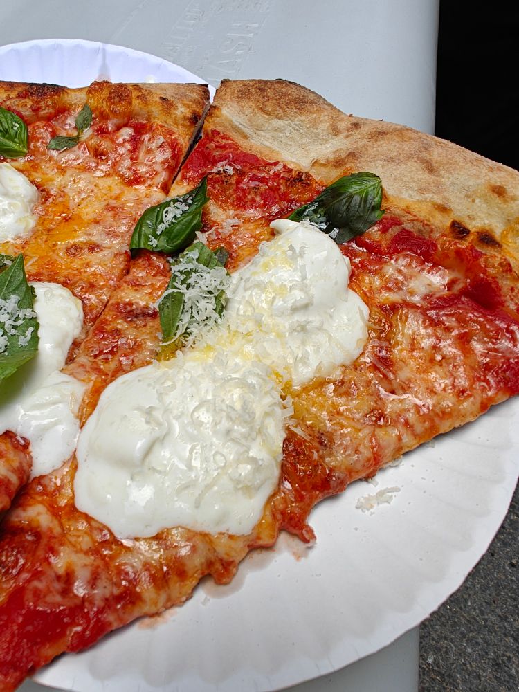 It's pizza! There's basil leaves, shredded parm, and dollops of wet burrata cheese on top.