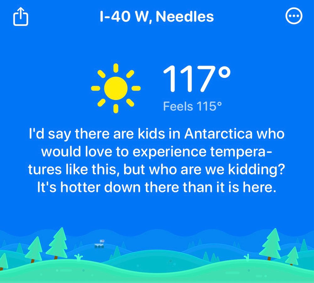Screenshot of Carrot Weather app with a blue sky and green landscape graphic that has the text I-40 W, Needles temperature of 117°, feels like 115°. The message says: I'd say there are kids in Antarctica who would love to experience temperatures like this, but who are we kidding? It's hotter down there than it is here.