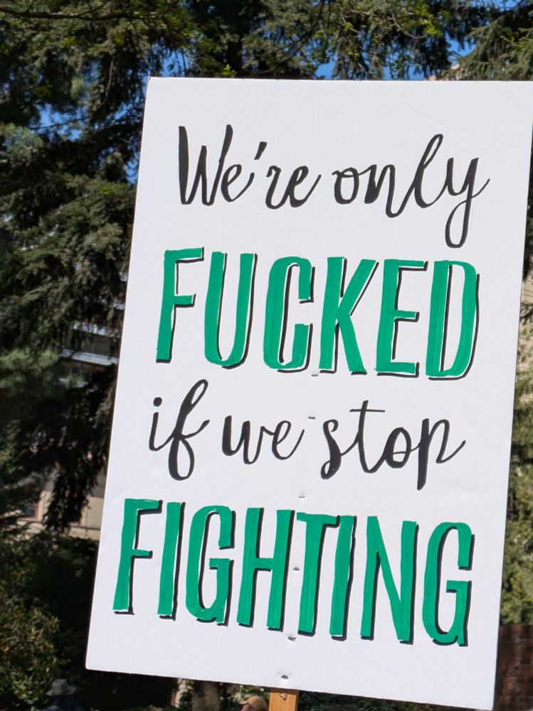 Picture of a protest sign that says: We're only FUCKED if we stop FIGHTING