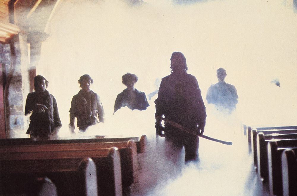 A movie still of ghost pirates from The Fog standing among church pews. 