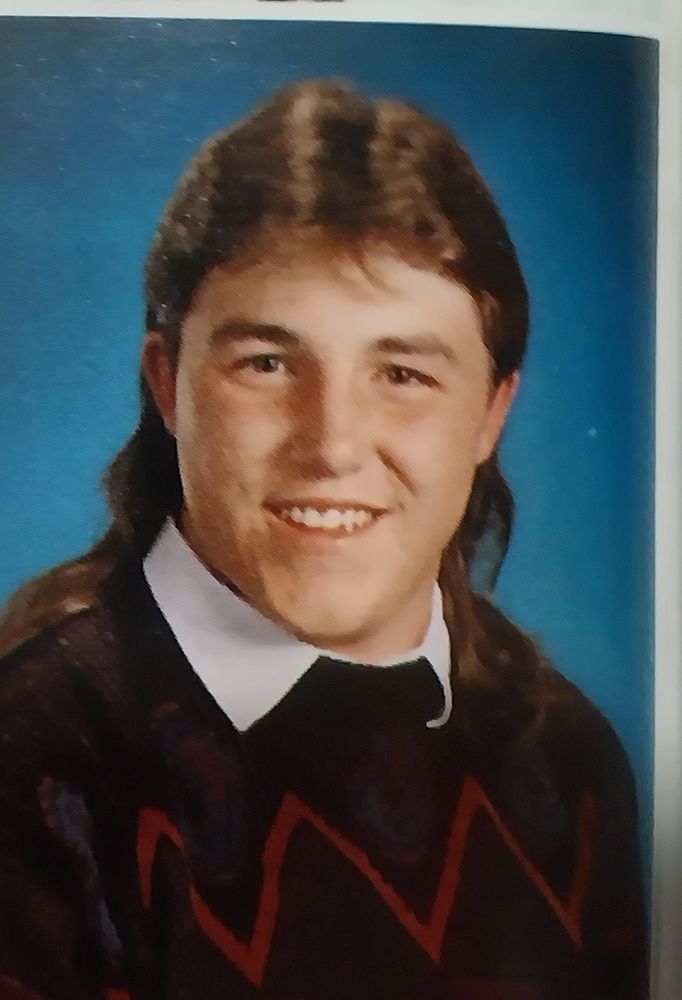 Eva at 17, pretransition, sporting a mullet and a Cosby sweater.