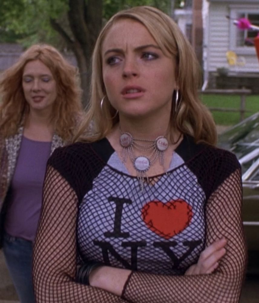 lindsay lohan as lola steppe in 
confessions of a teenage drama queen she is frowning and crossing her arms, she’s wearing an I ❤️ NY t-shirt with fishnet top above it 