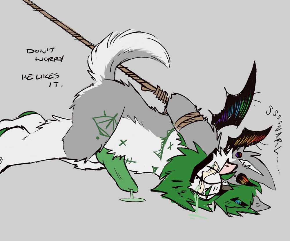 A digital drawing of a gray and green wolf character. He has black howns and a tail, and a green mane. His belly, muzzle, and legs are white while the rest of him is gray. He has top surgery scars and an eye-like symbol on his thigh. He is laying face down on the ground, snarling, with his hips slightly raised to show his green cock. His arms are tied with rope behind his back and he is wearing a muzzle and snarling. Text on the left reads "Don't worry. He likes it."