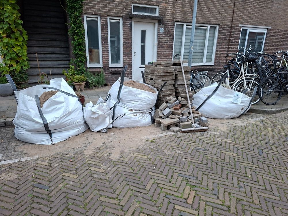 Zakken zand en stapels tegels.