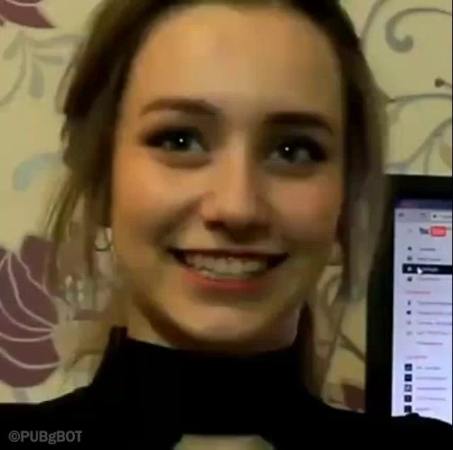 a close up of a woman 's face smiling in front of a computer monitor .