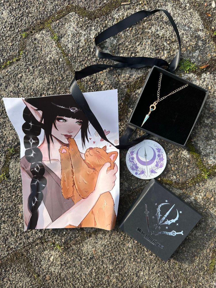 Picture taken outside on cobblestone. On the picture is a art print of Shadowheart from BG3 playing with a ginger cat, the lyrium Dahger from Dragon Age as a little golden necklace in a black box and a sticker of a half moon in purple, a spear and night orchids

