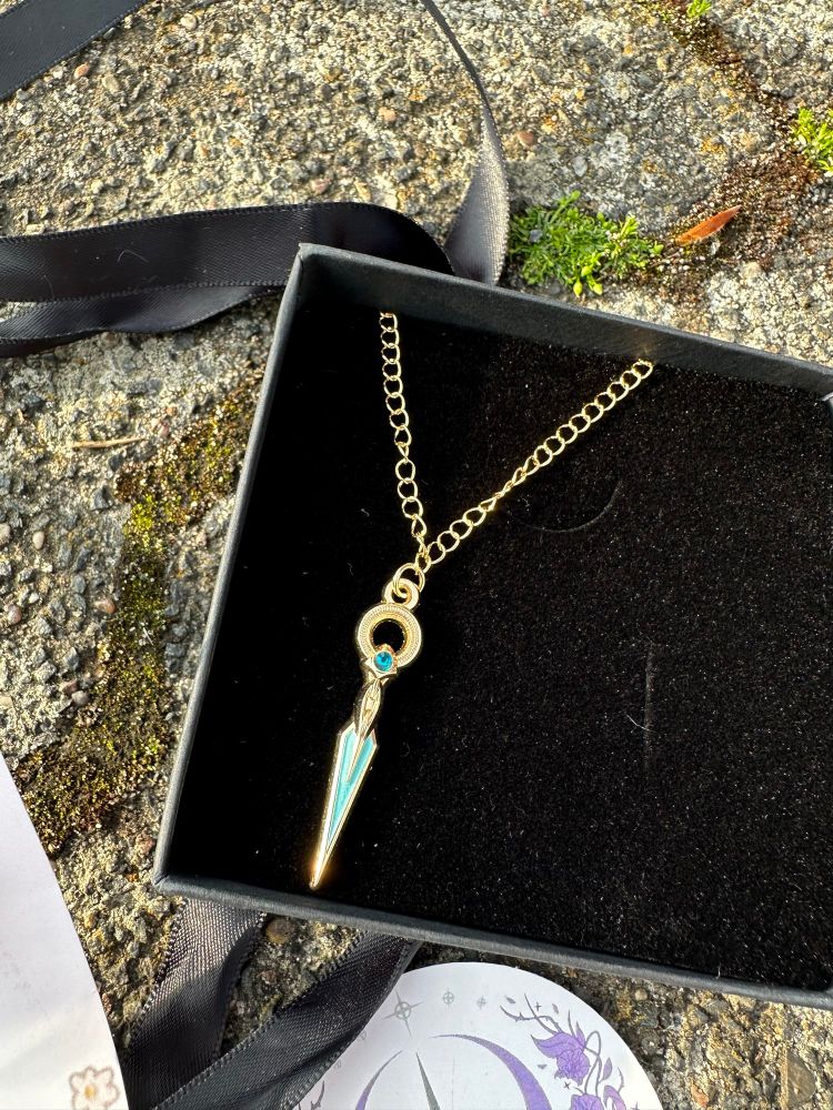 Close up of the golden lyrium dagger necklace in a black box