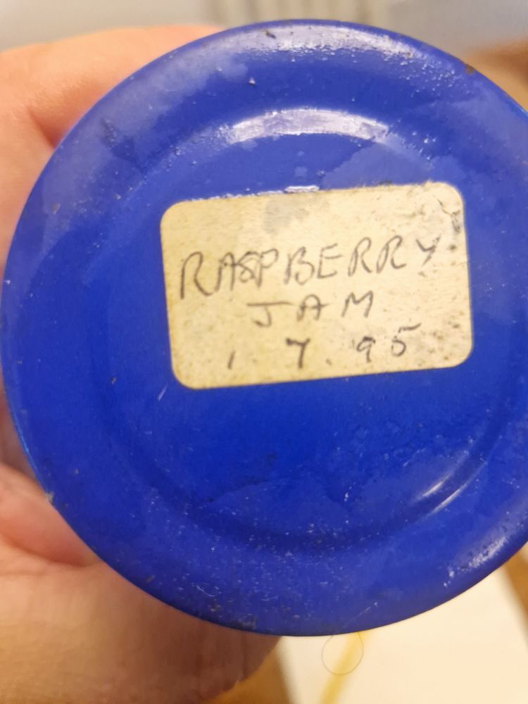 Blue jam jar lid with handwritten label saying 