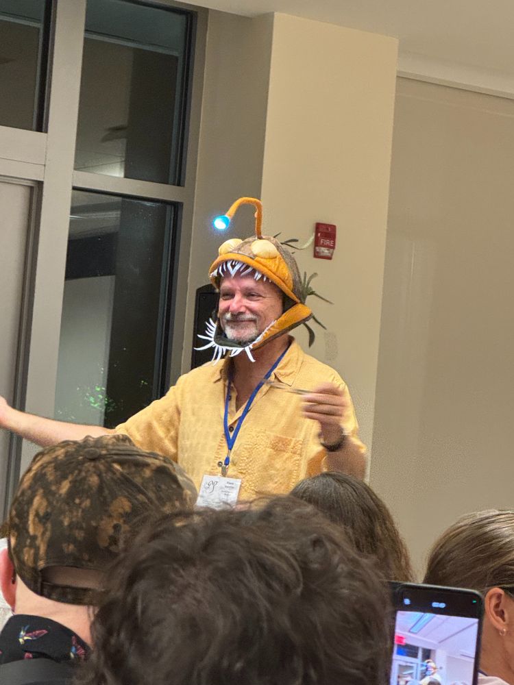 A photo of a man wearing a novelty hat in the shape of an anglerfish