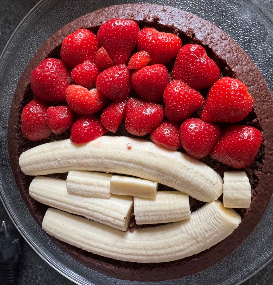 Der Boden eines Maulwurfkuchens bedeckt mit Bananen und Erdbeeren 