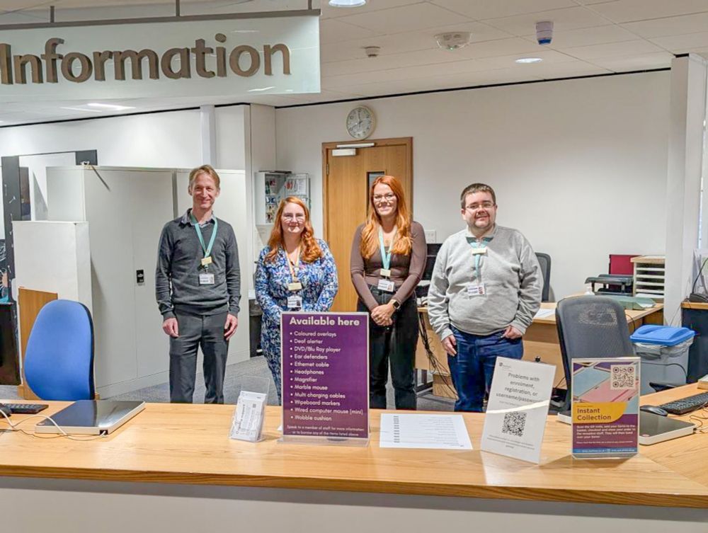 Four friendly staff at Help and Information Desk