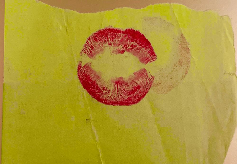 Papierschnipsel mit rundem Lippenstift-Kussmund