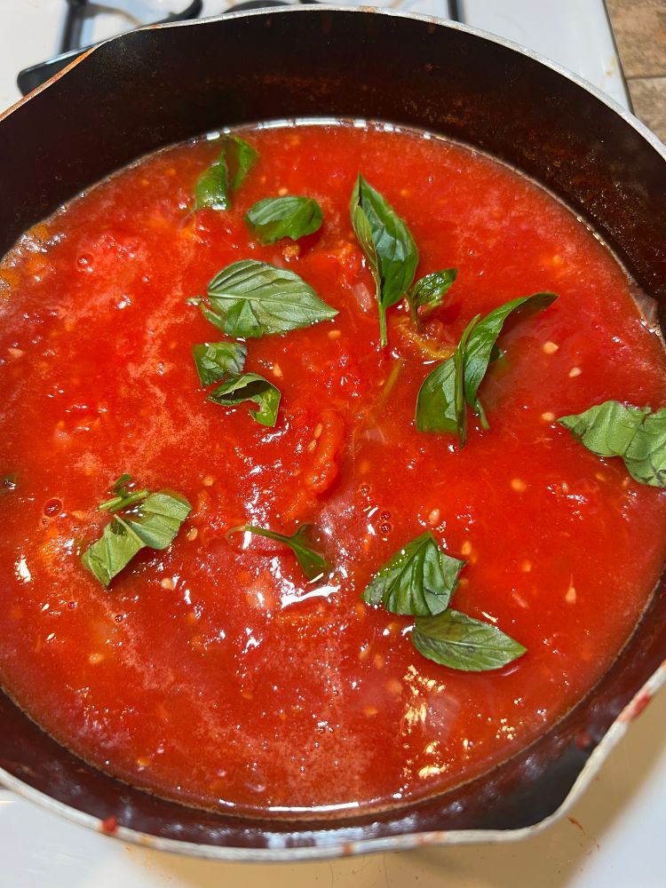 Marinara sauce with basil leaves in a pot