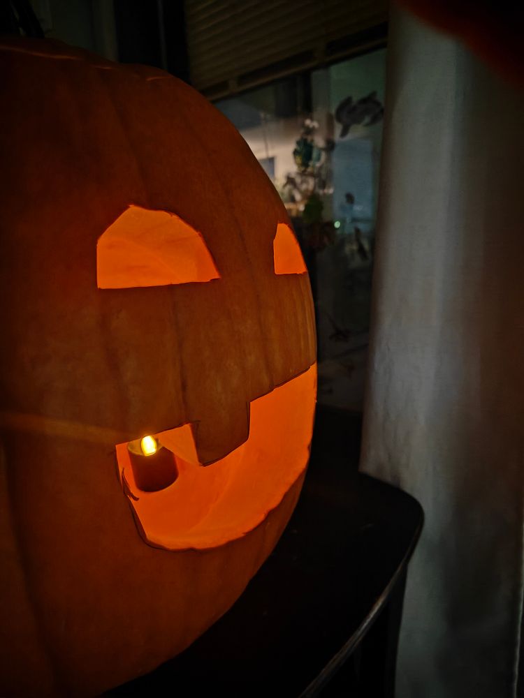 Photo of the back side of the dog jack-o'-lantern, showing another face with a big happy smile and one dull tooth.