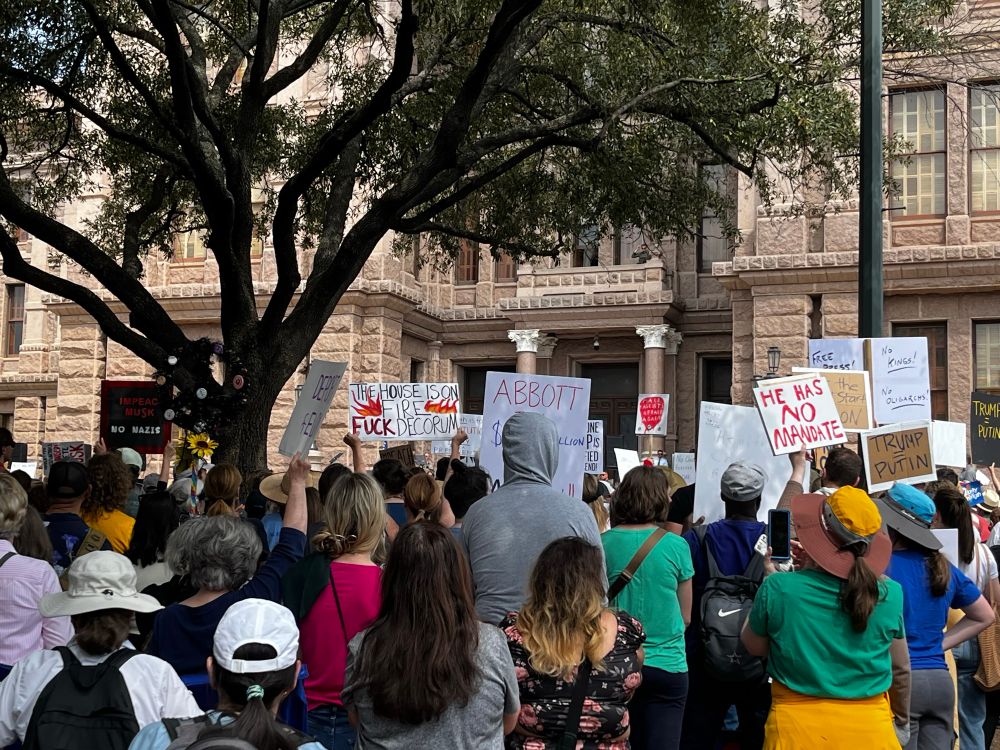 Crowd of resistors holding up protest signs while Elizabeth Warren speaks. 
