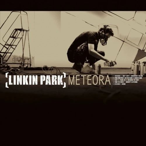 cover art of linkin park's METEORA album (2003), a yellow-tinted grayscale photo of a man in a gas mask. he is squatting/kneeling with a can of spray paint in hand and several other csns scattered on the ground around him, presumably mid-graffiti-project.