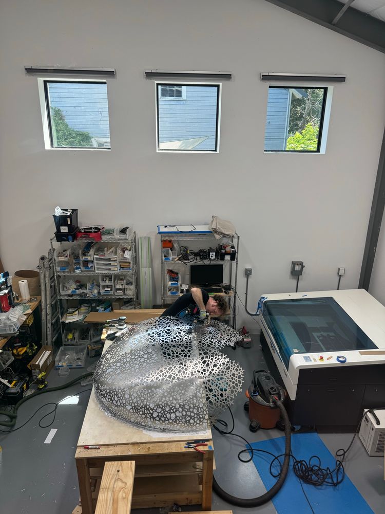 Jesse rivets a giant aluminum leaf skeleton from from lasercut panels into a rounded form