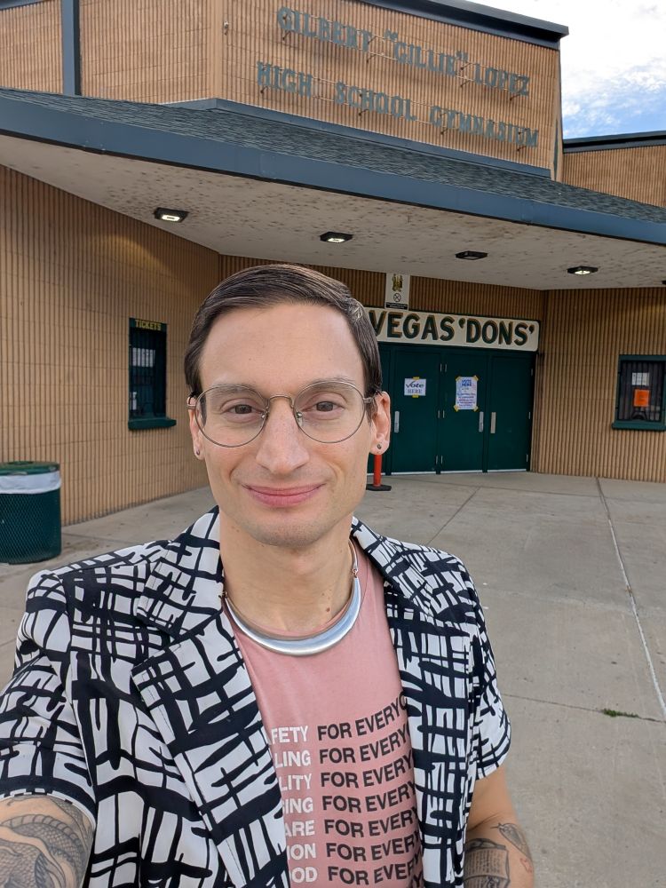Jess standing in front of a high school gymnasium building being used as a polling place on election day. 