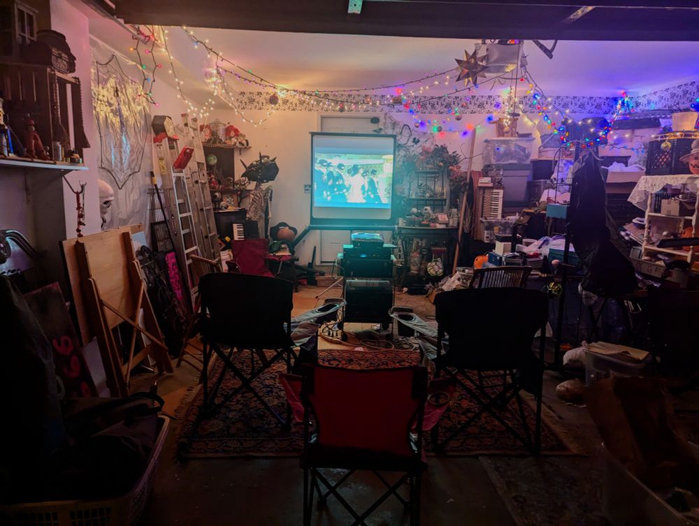 garage set up with chairs, a projector and screen 