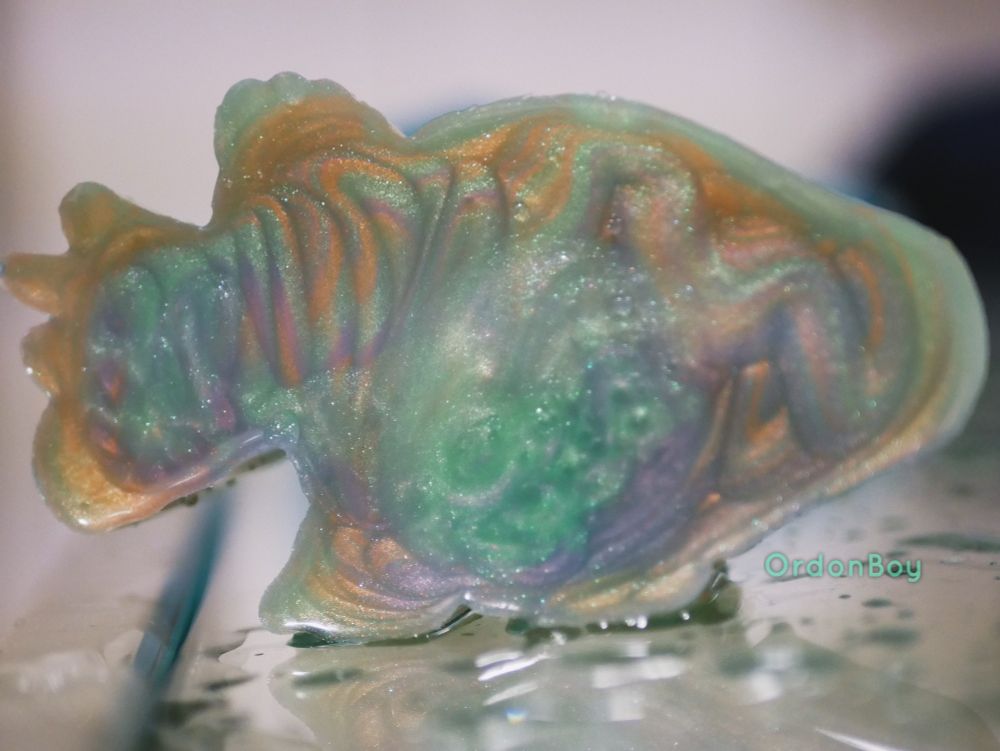 Dinosaur squishie in many sparkly colour swirls made by Velociraptoys a France based adult silicone shop