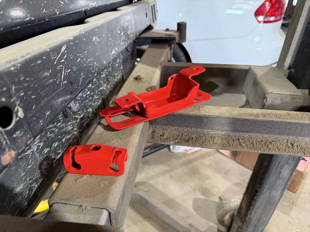 Jeep wrangler emergency brake brackets painted bright red. This photo shows the rear adjuster and inside handle mounting bracket. 