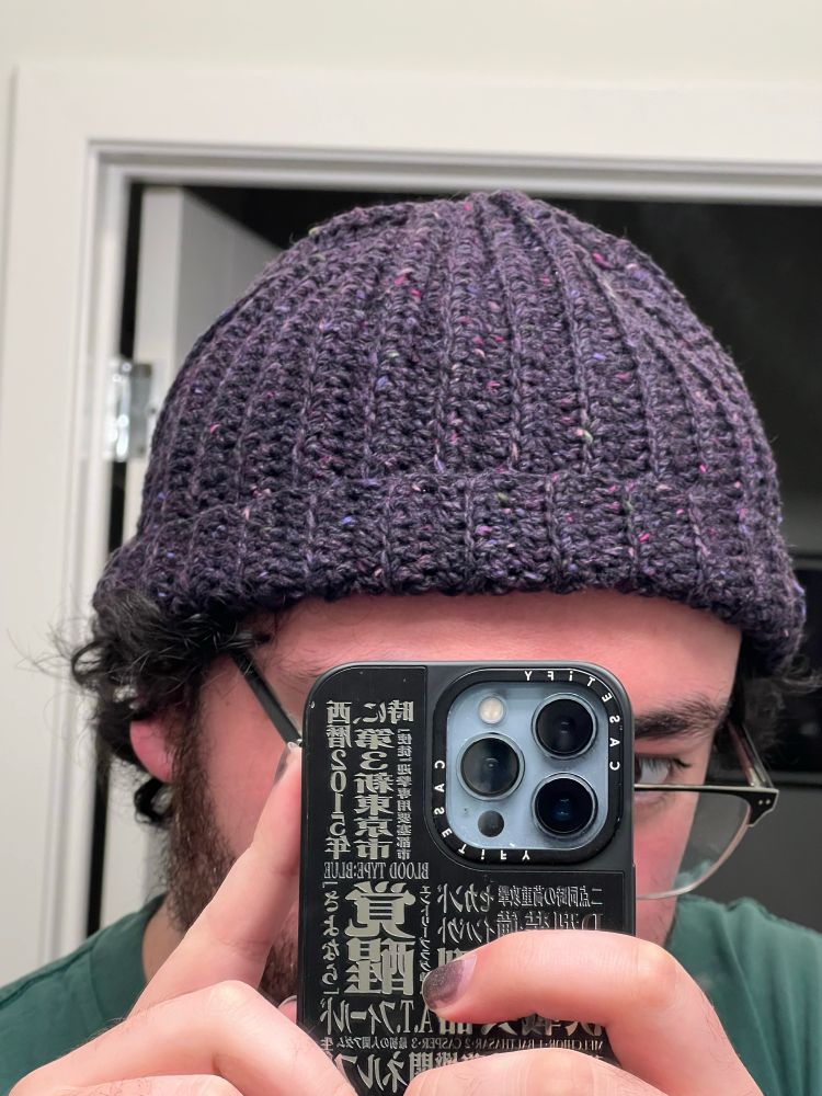A homemade wine colored beanie being worn by the creator